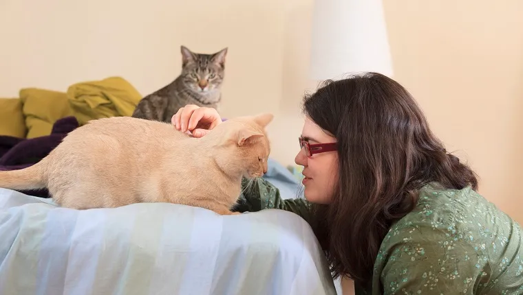 Woman with Asperger syndrome playing with her pet cats