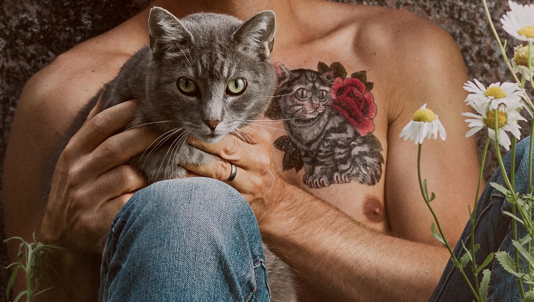 Man with cat tattoo and his pet cat