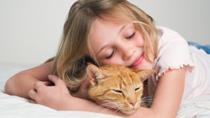 girl hugging cat