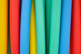 Studio photograph of colorful foam floating swim noodles.
