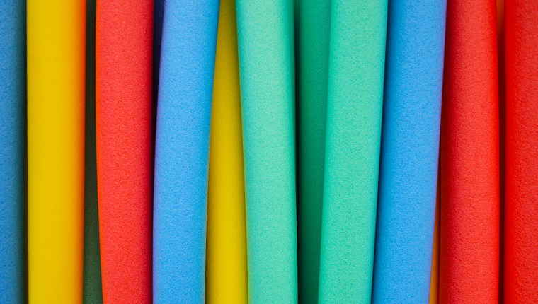 Studio photograph of colorful foam floating swim noodles.