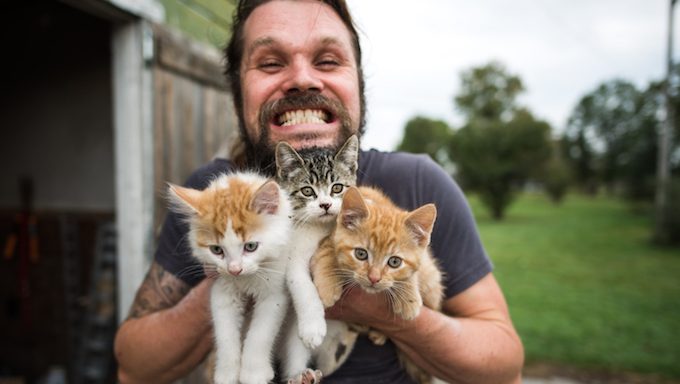 man holding three kittens