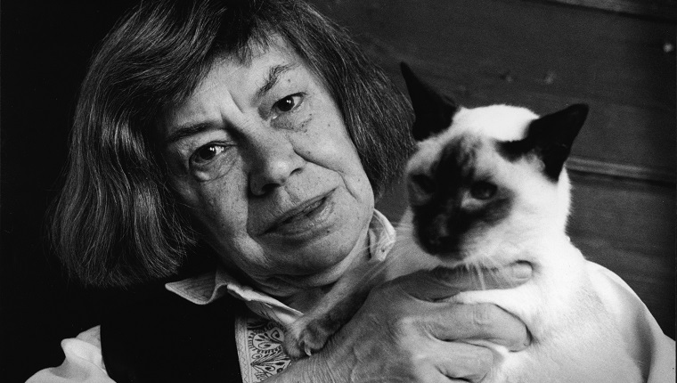 Portrait of American mystery and suspense author Patricia Highsmith (1921 - 1995), creator of the character Tom Ripley, as she holds a Siamese cat, 1991. 
