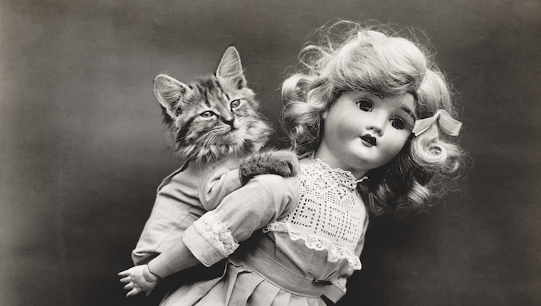 Kitten riding plastic doll