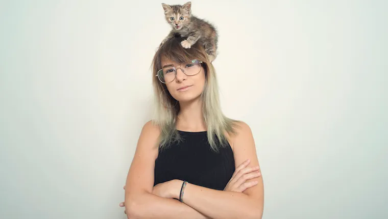 Woman with kitten on her head