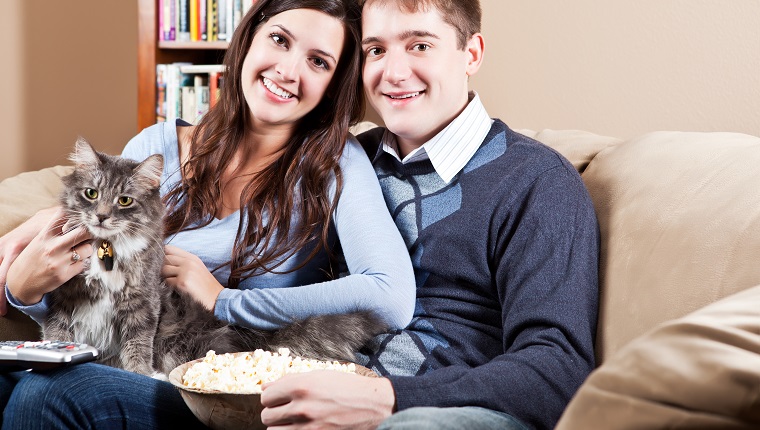 A couple sitting on sofa relaxing at home