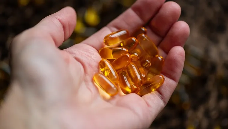 many capsules of gold color lies in the hand on the background of a leopard