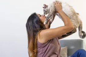 woman hugging and kissing her cat after adopting cat