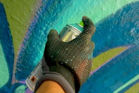 Close-Up Of Human Hand Spray Painting Wall