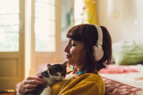 woman wearing headphones cuddling cat best cat names inspired by music