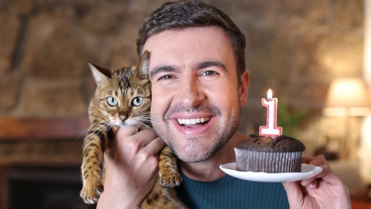 man celebrating cats first birthday codependent with cat