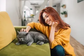 young woman caring for cat cat-sitting etiquette for pet sitters