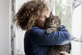 A woman cuddling cat after feline was reunited with family.