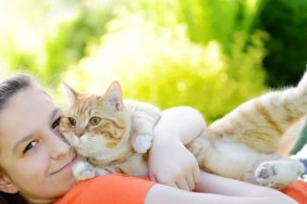 A girl cuddling with a cat, like the teenage girl who sought comfort from a hospital cat in the UK.